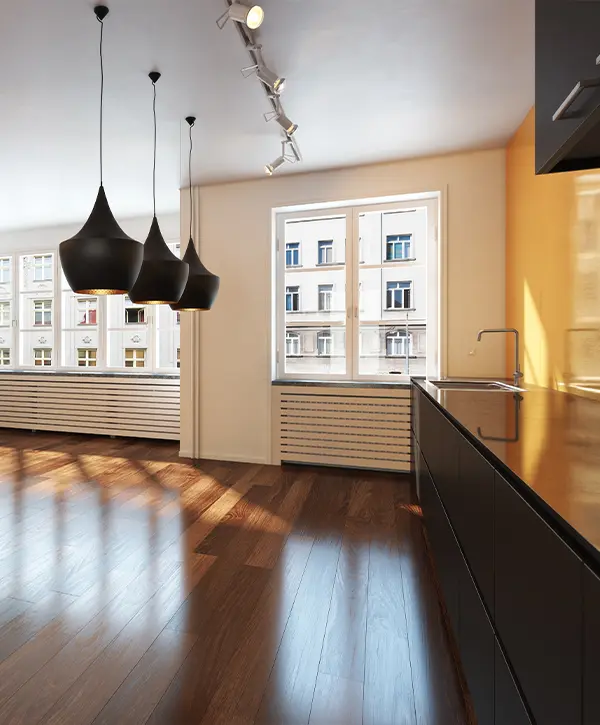 Modern kitchen with dark cabinets and glossy refinished hardwood floors reflecting natural light