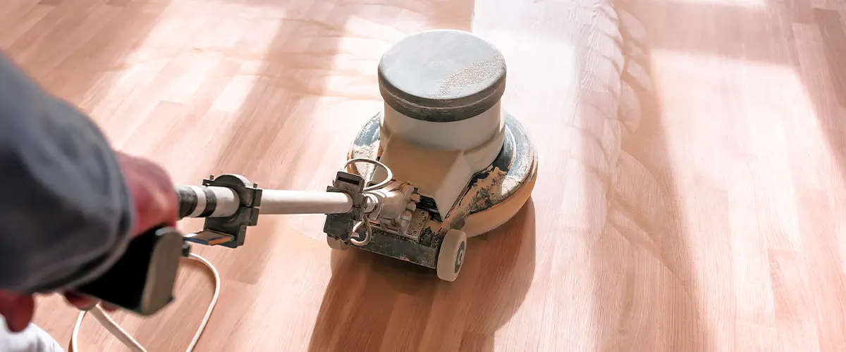 Refinished hardwood floor in a bright, modern dining and living area with natural light