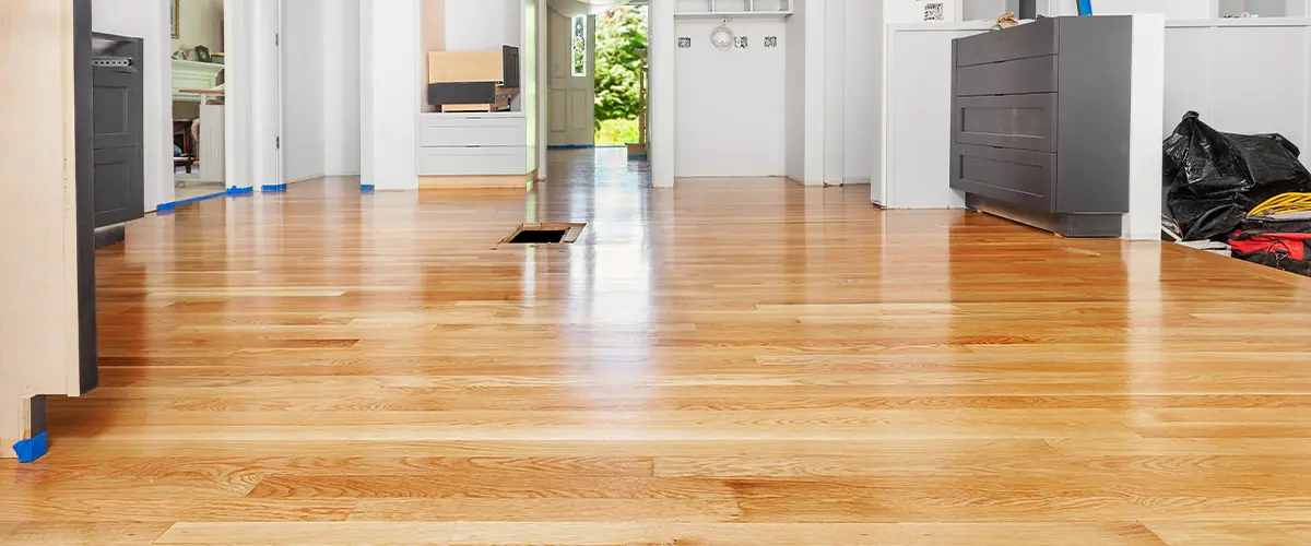 Bright modern kitchen with refinished hardwood floors and white cabinetry, offering a sleek, contemporary look.