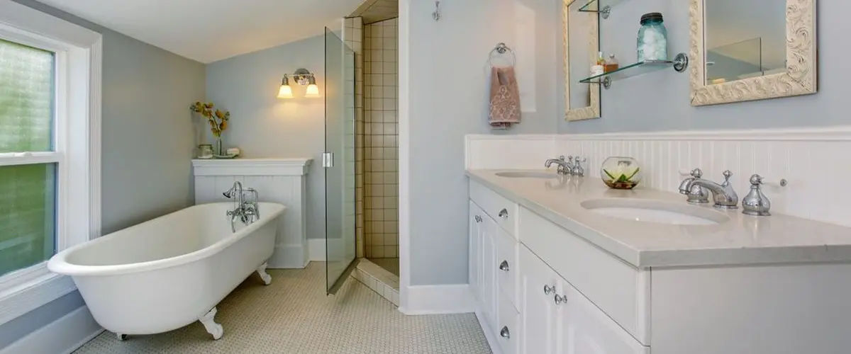 Elegant bathroom with freestanding tub, glass shower, and dual vanity in a bright, airy space.