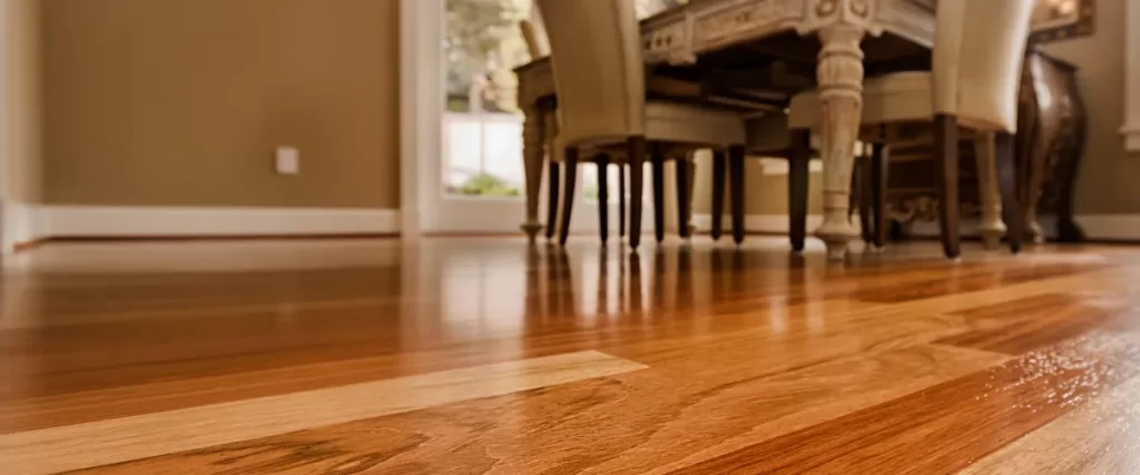 Low-angle view of a dining area with rich, polished hardwood floors.