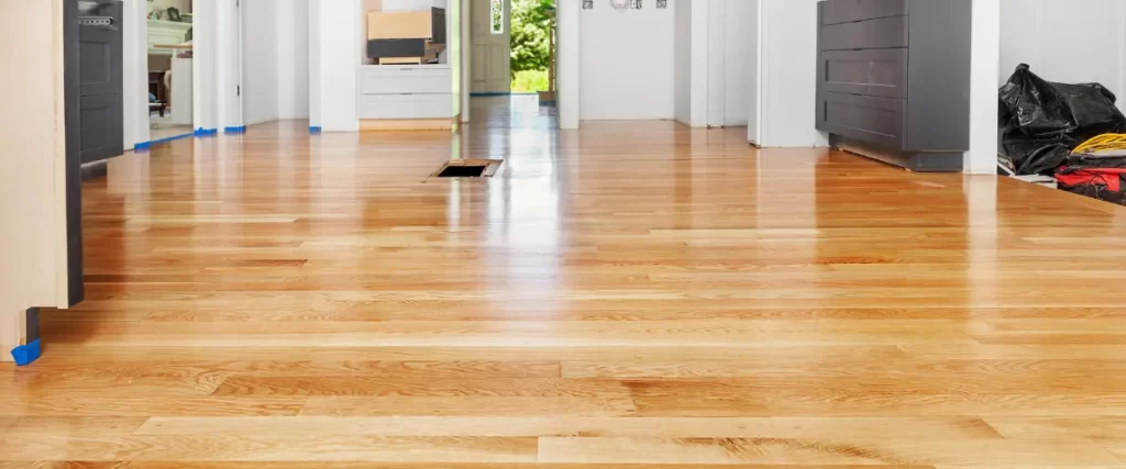 Freshly sanded and polished light wood flooring in a bright living space.